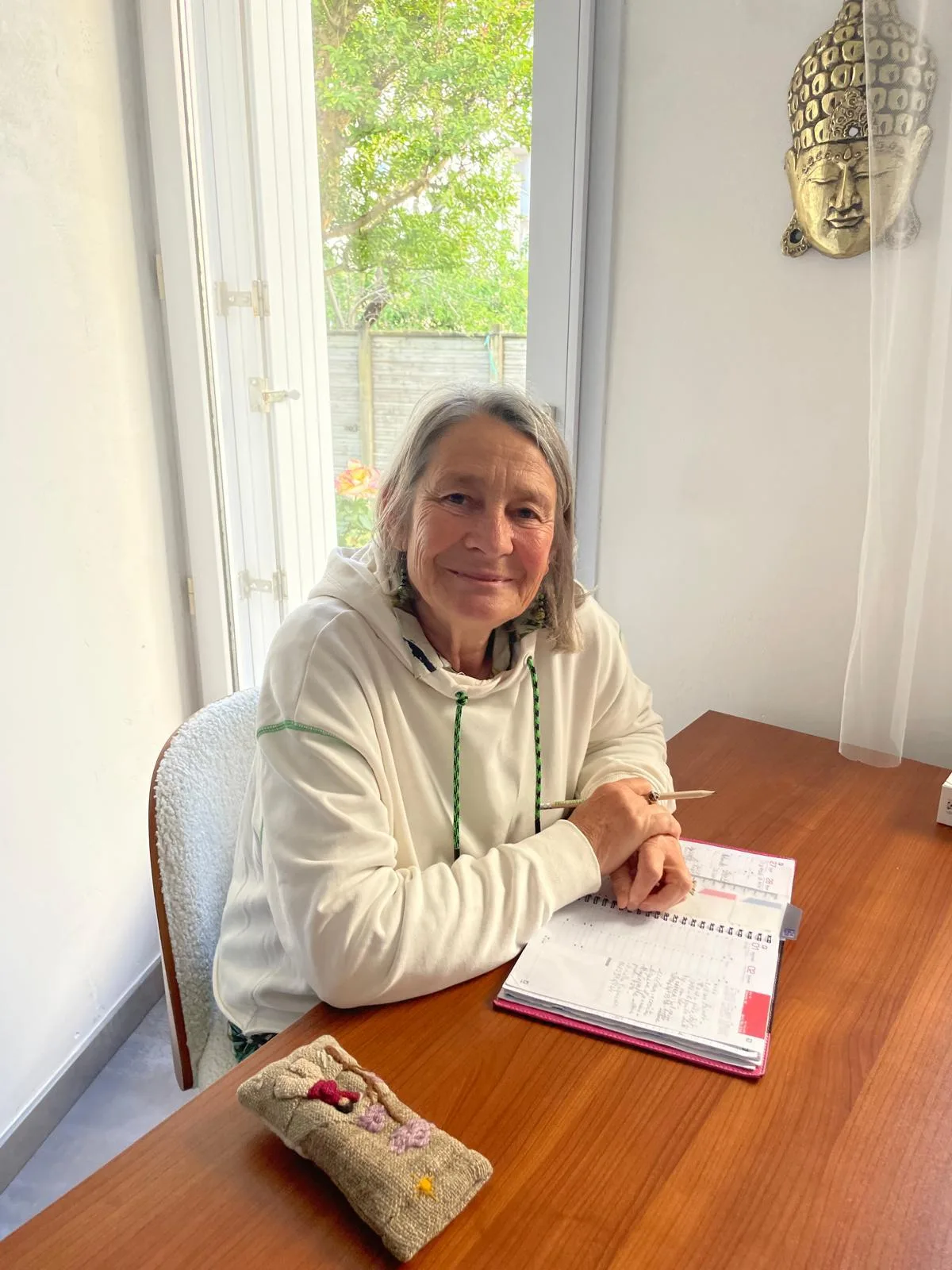 Catherine Fonteneau au Cabinet des Roses, souriante près du Bouddha doré